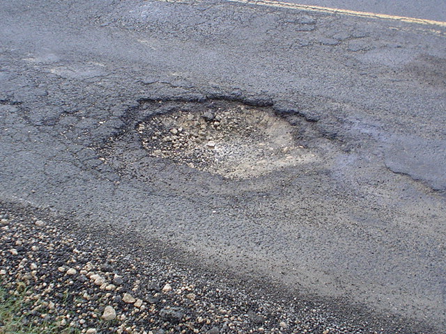 Pothole on a residential road after heavy rains.