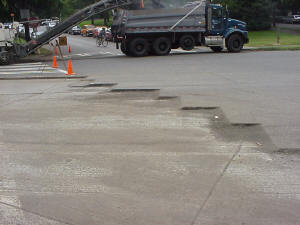 Milled road showing complete removal of the HMA overlay, which exposes the PCC slabs beneath.