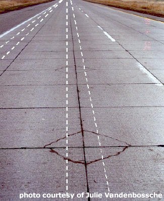 Typical Corner Breaks Resulting from Joints Placed in the Wheelpath (the White Dashed Lines Represent the Approximate Wheelpaths).